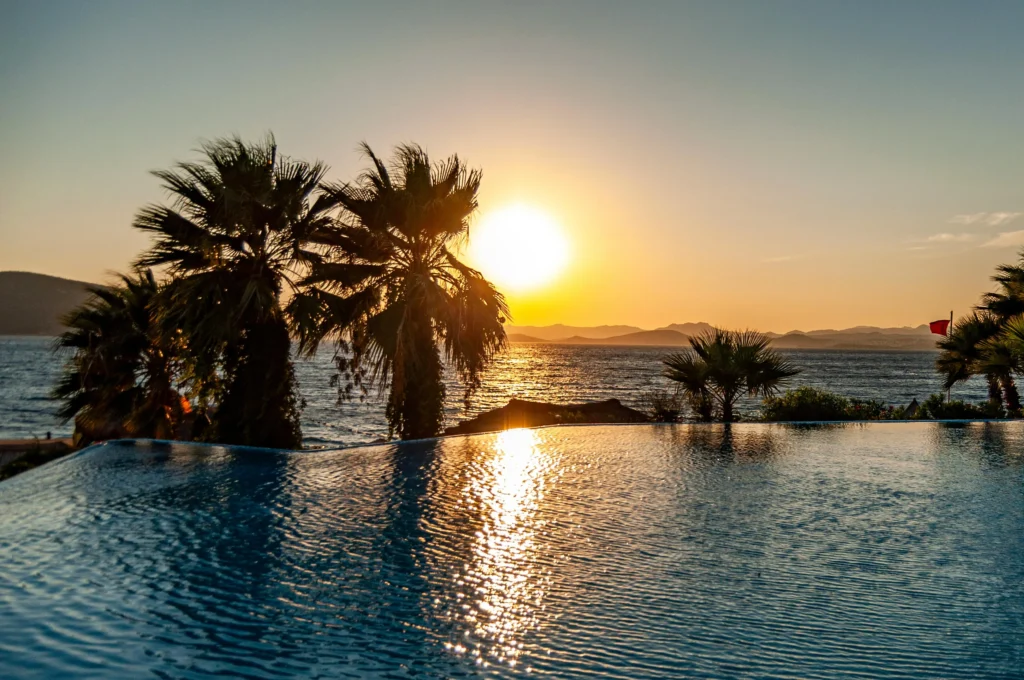 Beachfront resort in Pattaya with an infinity pool overlooking the ocean during sunset